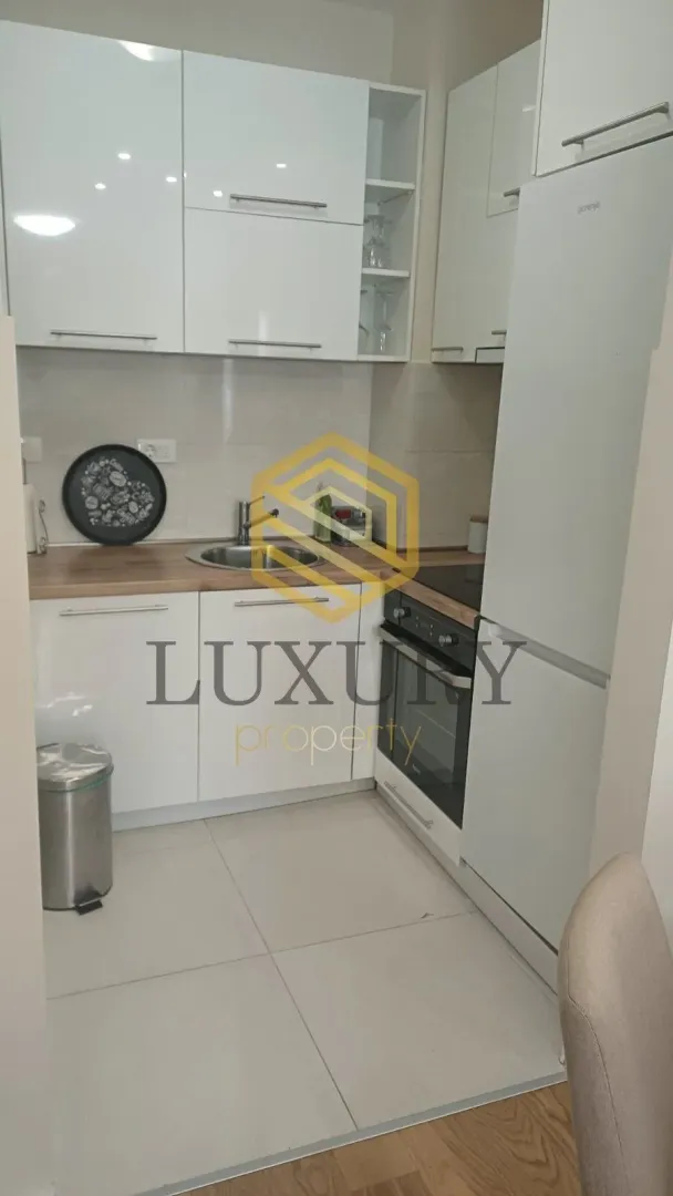 Small kitchen with white cabinets and built-in appliances.
