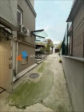 Side passageway and courtyard next to the building with an entrance door. - image 11
