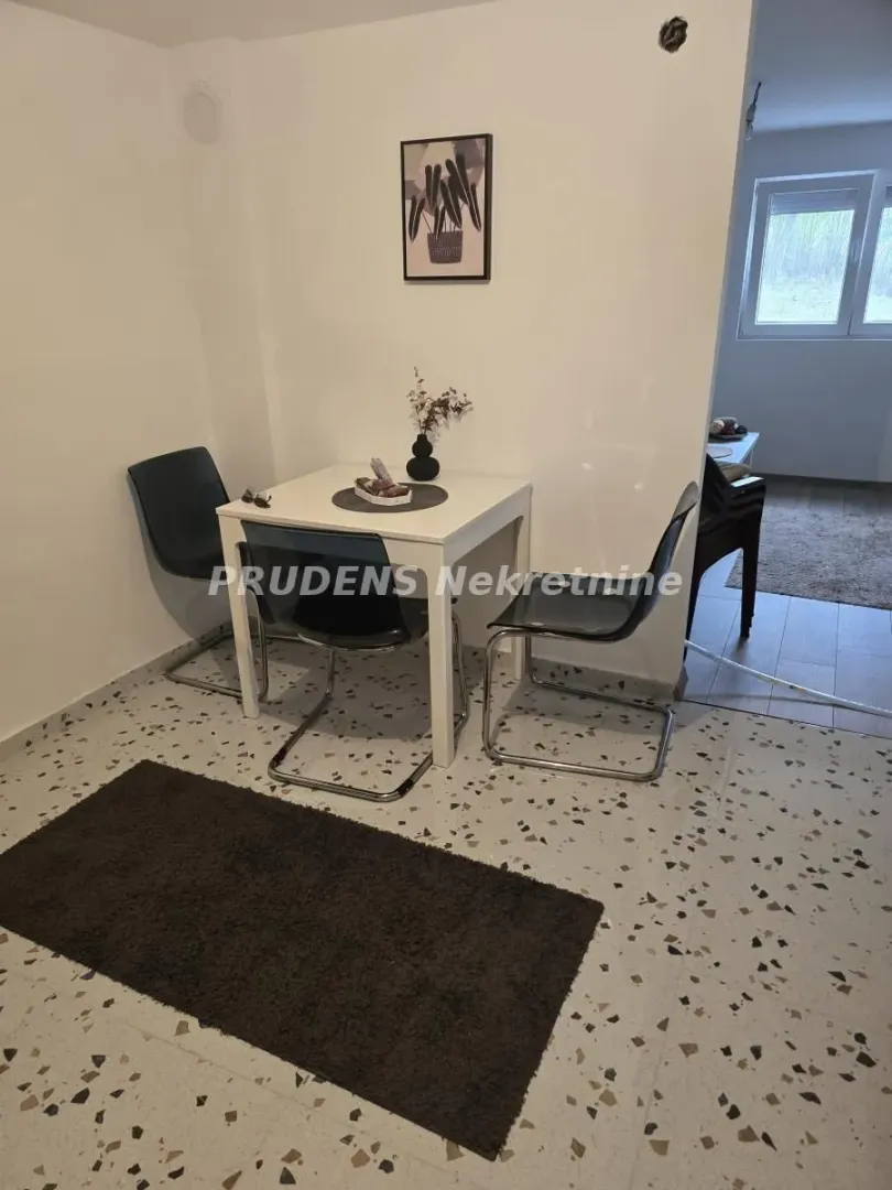 Smaller dining table with chairs as part of the living room.