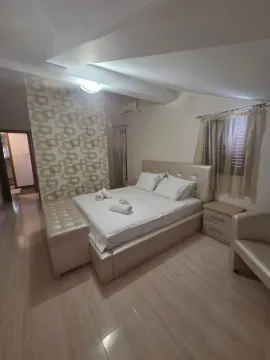 Bright bedroom featuring a large double bed and decorative wallpaper. - image 10
