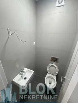 Manje kupatilo sa sivim pločicama, umivaonikom i šoljom. - image 8