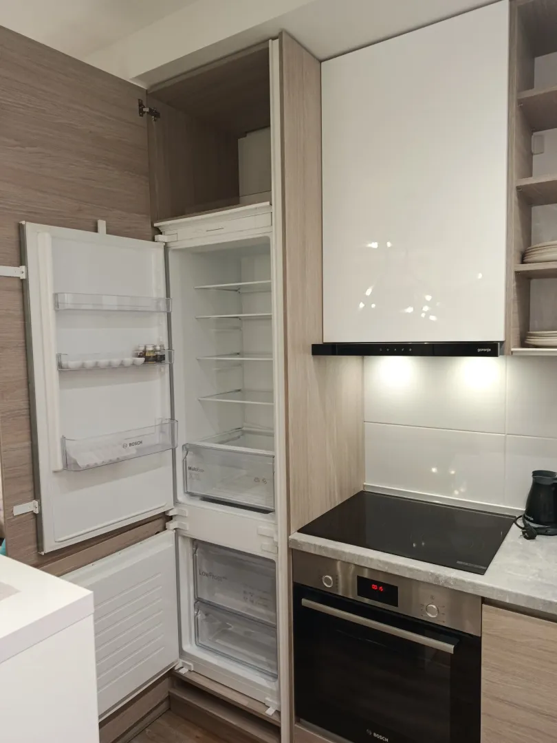 Kitchen with built-in refrigerator, oven, and hob.