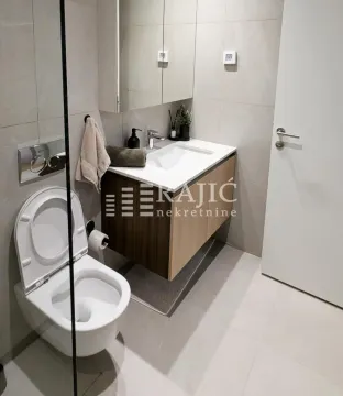 Modern bathroom equipped with a washbasin and toilet. - image 12