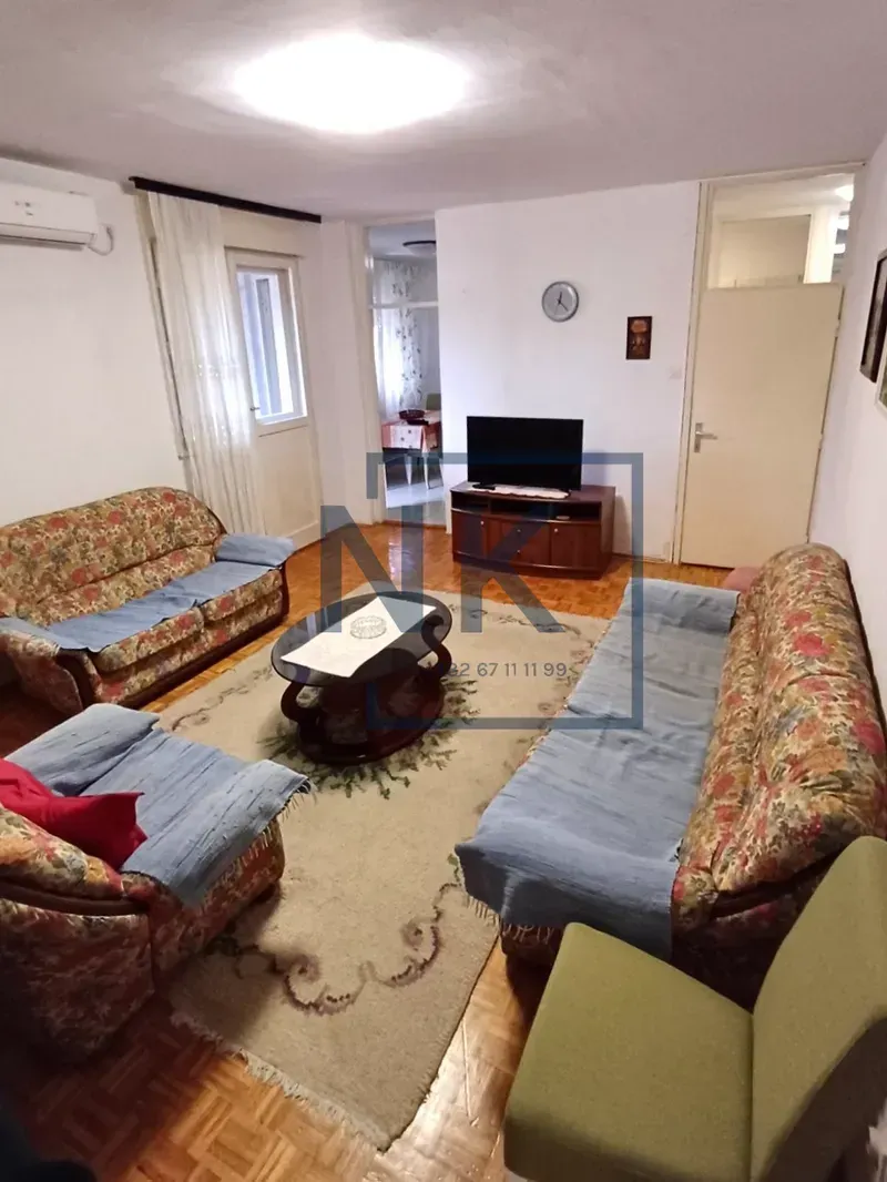 Living room with sofa set, coffee table, and TV.