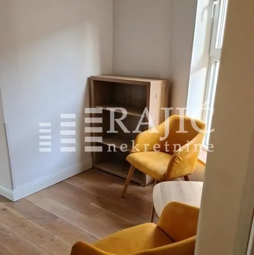 Small living room with yellow armchairs and a wooden bookcase.