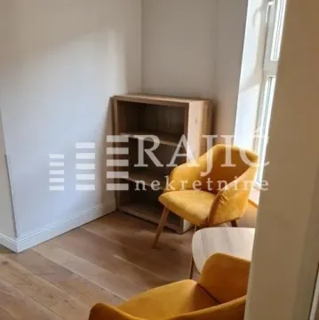 Small living room with yellow armchairs and a wooden bookcase. - image 3