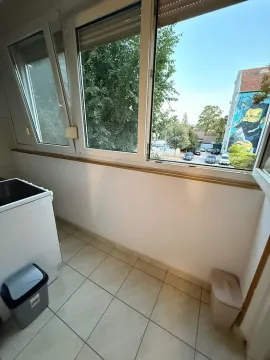 Zastakljeni balkon sa keramičkim pločicama i pogledom na ulicu. - image 5