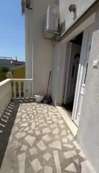 Terrace with tiled flooring and the entrance door of the house.