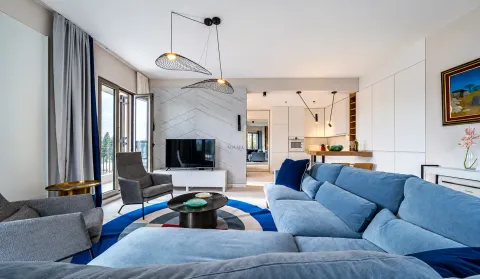 Modern living room with a blue sectional sofa, armchairs, and access to the terrace. - image 2