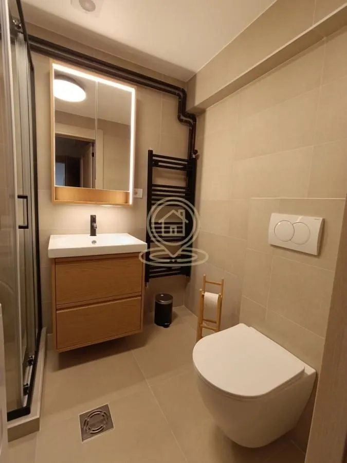 Moderno kupatilo sa tuš kabinom, umivaonikom i WC šoljom.