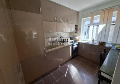 View of a furnished kitchen with beige cabinets and a window. - image 11