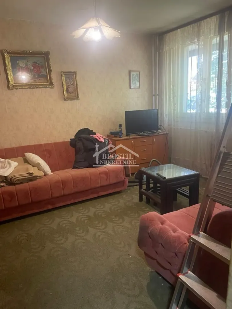 Dnevna soba sa garniturom za sedenje i televizorom.
