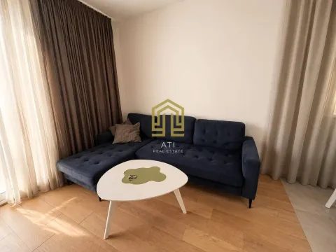Living room with a dark blue sectional sofa and a white coffee table. - image 4