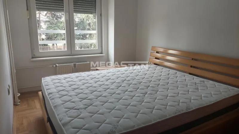 Spavaća soba sa bračnim krevetom i prozorom.