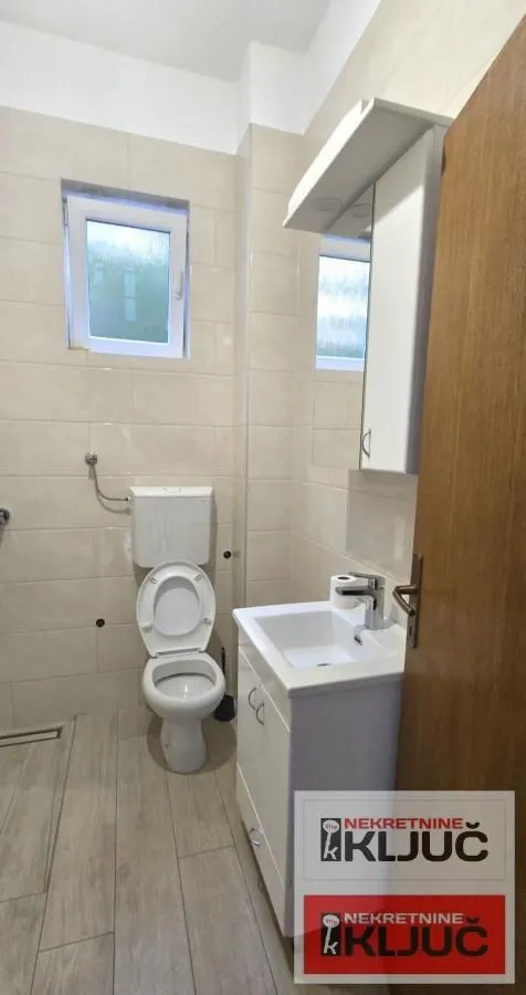 Bathroom equipped with sanitary ware and a white vanity unit with a sink.