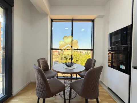 Dining area with a table, four chairs and a built-in kitchen with a window view. - image 5