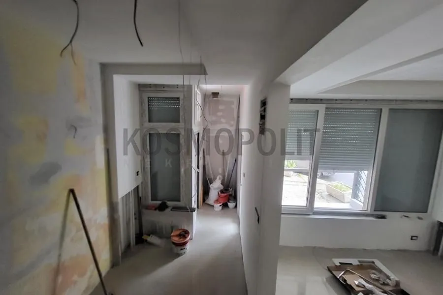 Unutrašnjost nekretnine u fazi renoviranja sa vidljivim građevinskim radovima i materijalima.
