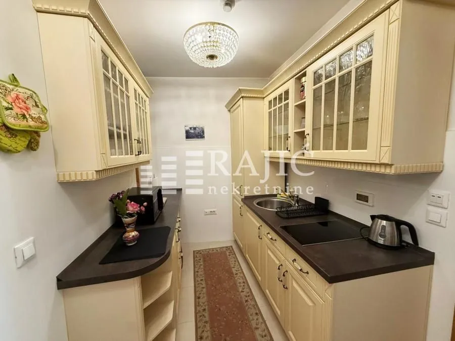 Small equipped kitchen with light cabinets and countertops.