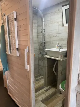 Manje kupatilo sa tuš kabinom i drvenim oblogama. - image 10