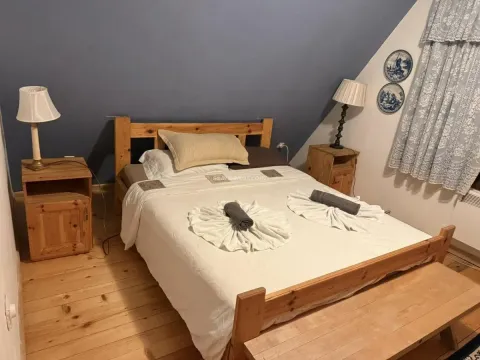 Namještena spavaća soba sa drvenim krevetom i noćnim stočićima. - image 10