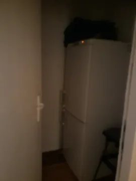 Tamna i zamućena fotografija frižidera u uglu prostorije. - image 6
