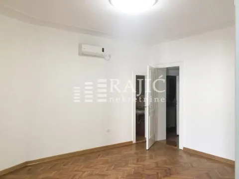 Empty room with wooden parquet flooring and an air conditioning unit on the wall. - image 2