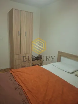 Furnished bedroom with a bed and a wooden wardrobe. - image 5