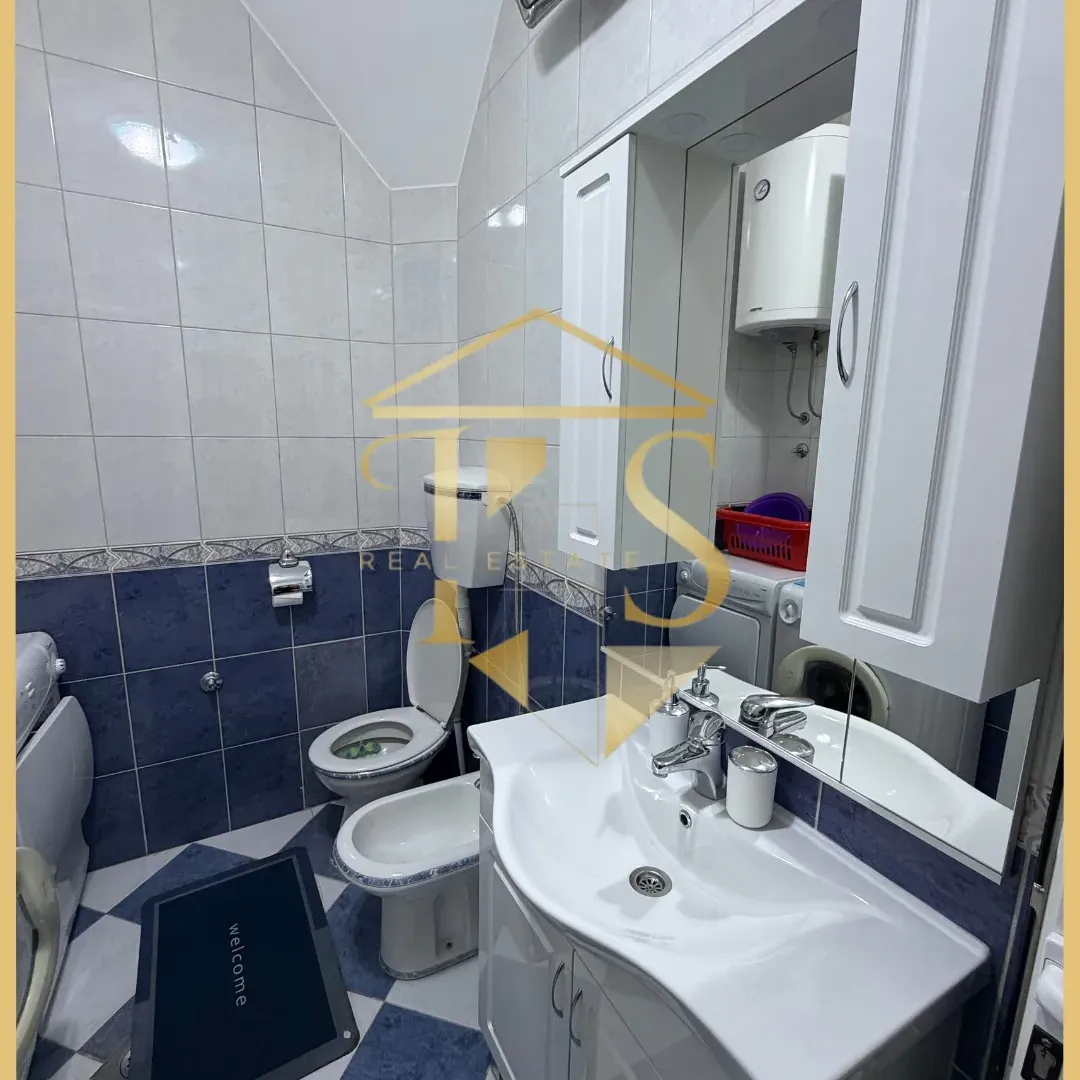 Renovirano kupatilo sa bijelim sanitarijama i pločicama u plavo-bijelim tonovima.