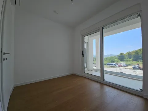Prazna soba sa drvenim podom i velikim balkonskim vratima. - image 4