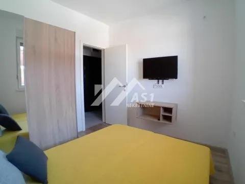 Nameštena spavaća soba sa bračnim krevetom, ormarom i televizorom na zidu. - image 7