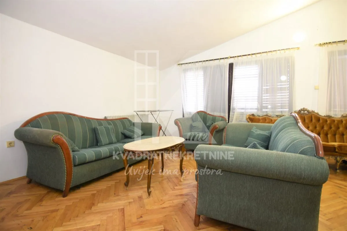 Spacious living room with a seating set and parquet flooring.