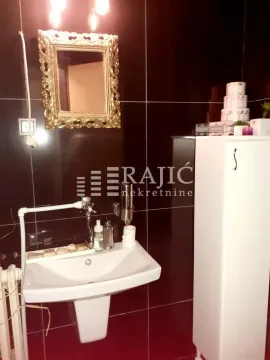 Small bathroom with a sink and a mirror with a decorative frame. - image 8