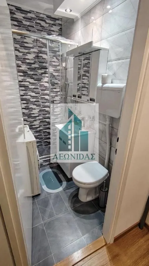 Small bathroom with a shower cabin, washbasin, and toilet.