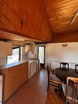 Kitchen with wooden furniture and a dining table. - image 16