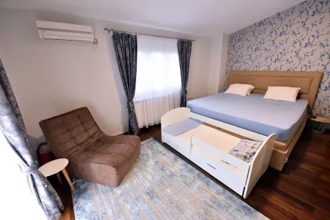 Bedroom with a double bed, an armchair, and a cot. - image 8