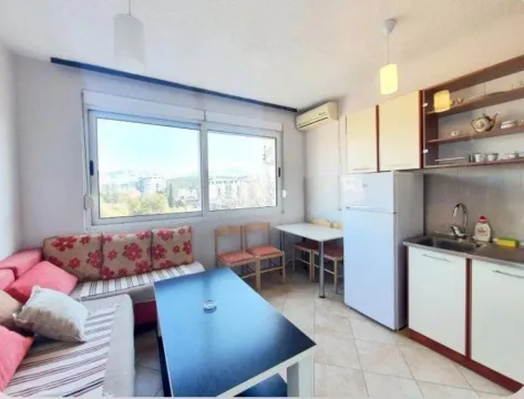 Smaller kitchen with a dining table and living area. - image 2