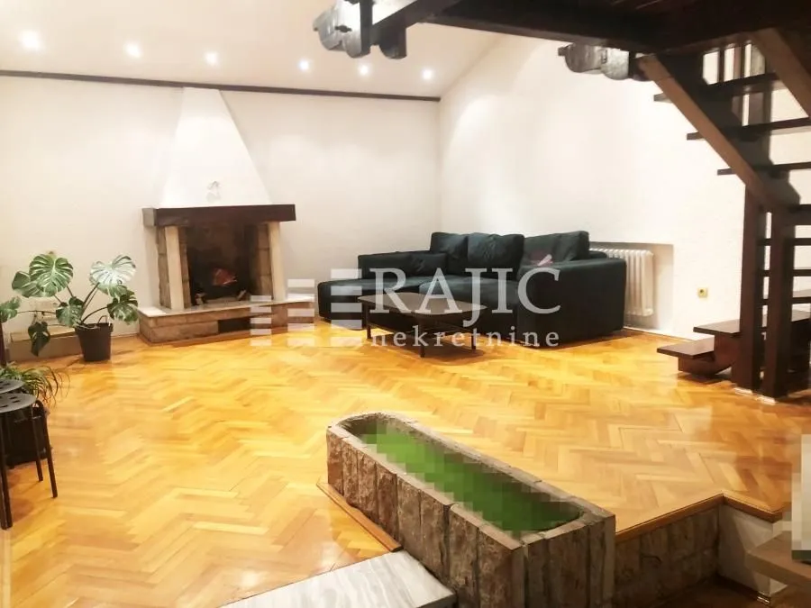 Spacious living room with a fireplace and wooden floor.