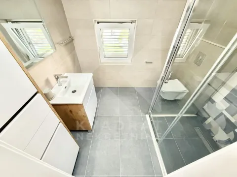 Modern bathroom with a shower cabin, washbasin, and toilet. - image 8