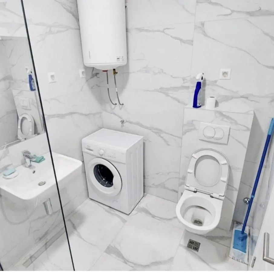 Savremeno opremljeno kupatilo sa sanitarijama, veš mašinom i bojlerom.