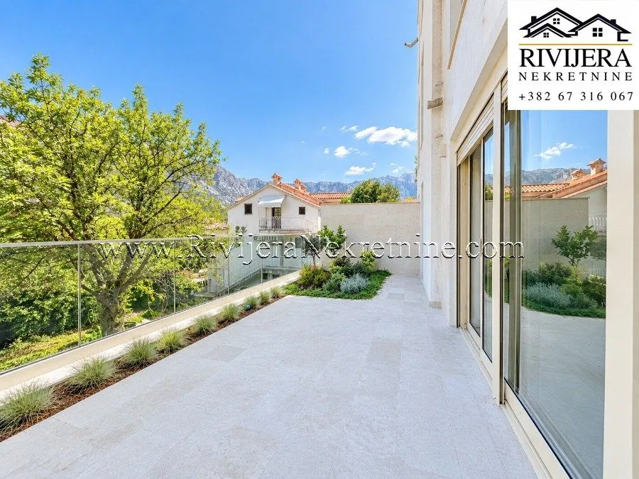 Spacious paved terrace with a glass railing and a view of the surroundings.