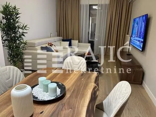 Living room with a sofa set, dining table, and TV.