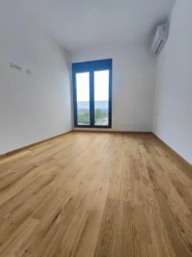Empty room with wooden flooring, white walls, and a window. - image 4