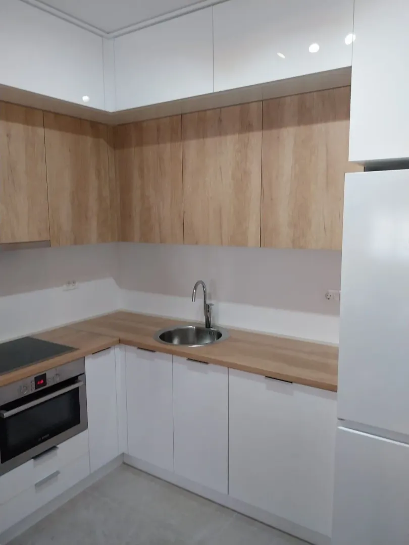 Modern kitchen with white and wooden cabinets.