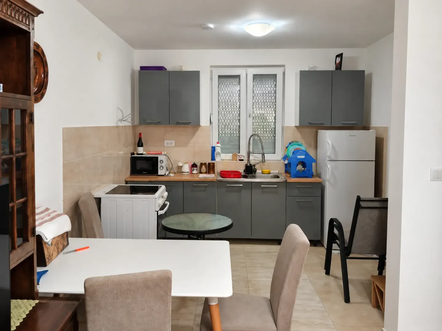 Kitchen with dining area and grey cabinets.