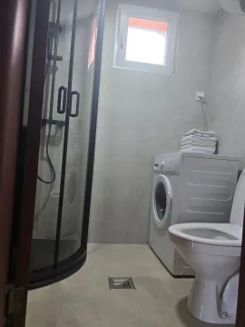 Modernly equipped bathroom with a shower cabin, washing machine, and toilet. - image 6