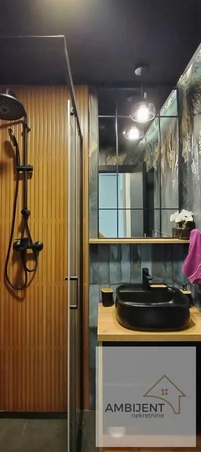 Modern bathroom with a walk-in shower, washbasin, and mirror.