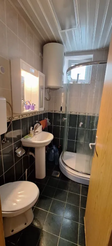 Manje kupatilo sa tuš kabinom, umivaonikom i wc šoljom.