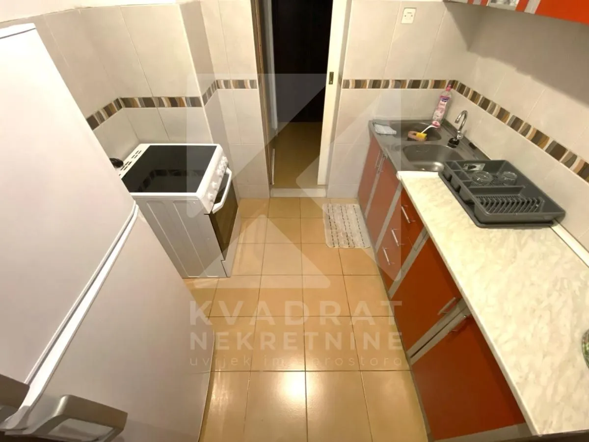 Small kitchen with a sink, stove, and kitchen cabinets.