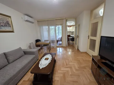 Living room with a sofa, coffee table and a view towards the dining area and balcony. - image 3