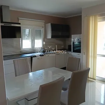 Kitchen with dining area and white units. - image 4